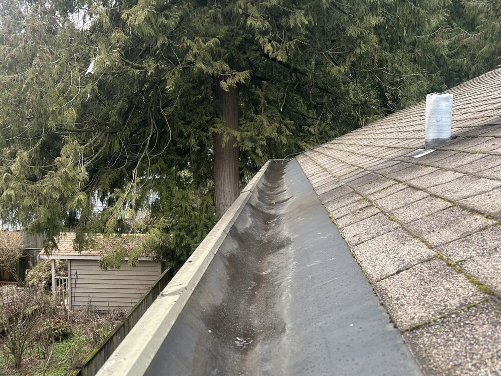 The same gutter run after cleaning, flushed clear end to end